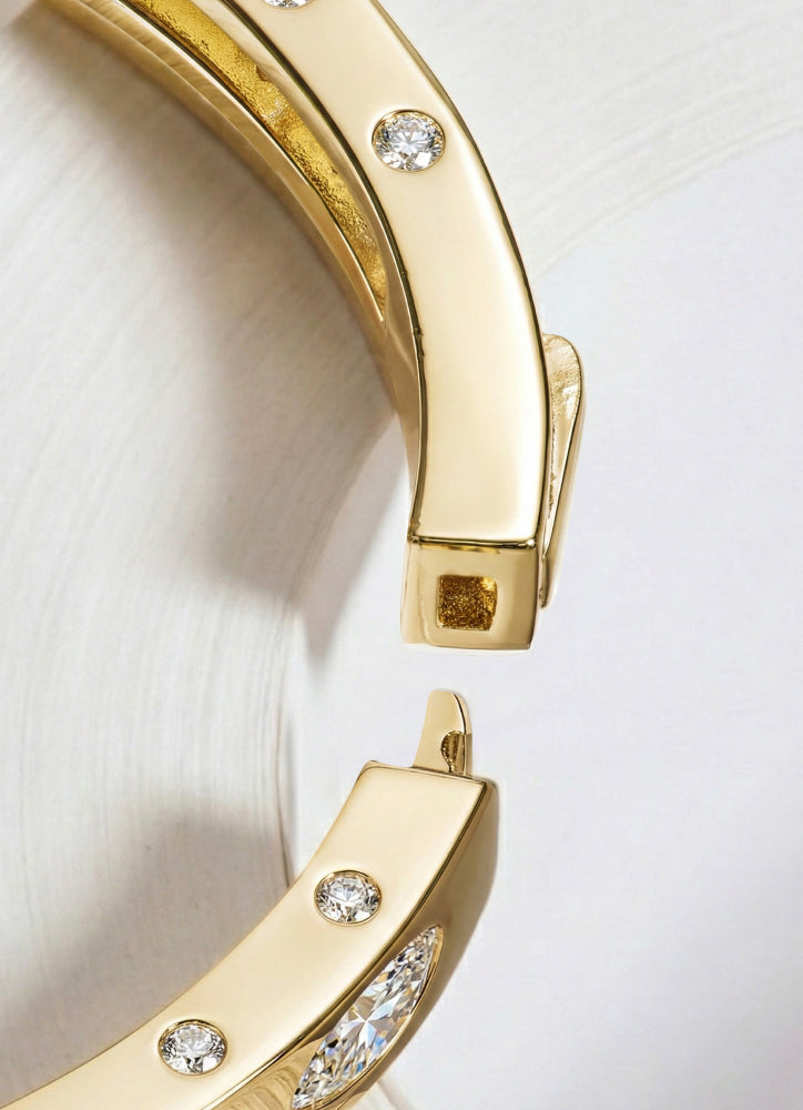 Close-up of a gold bracelet with diamond accents on a light background
