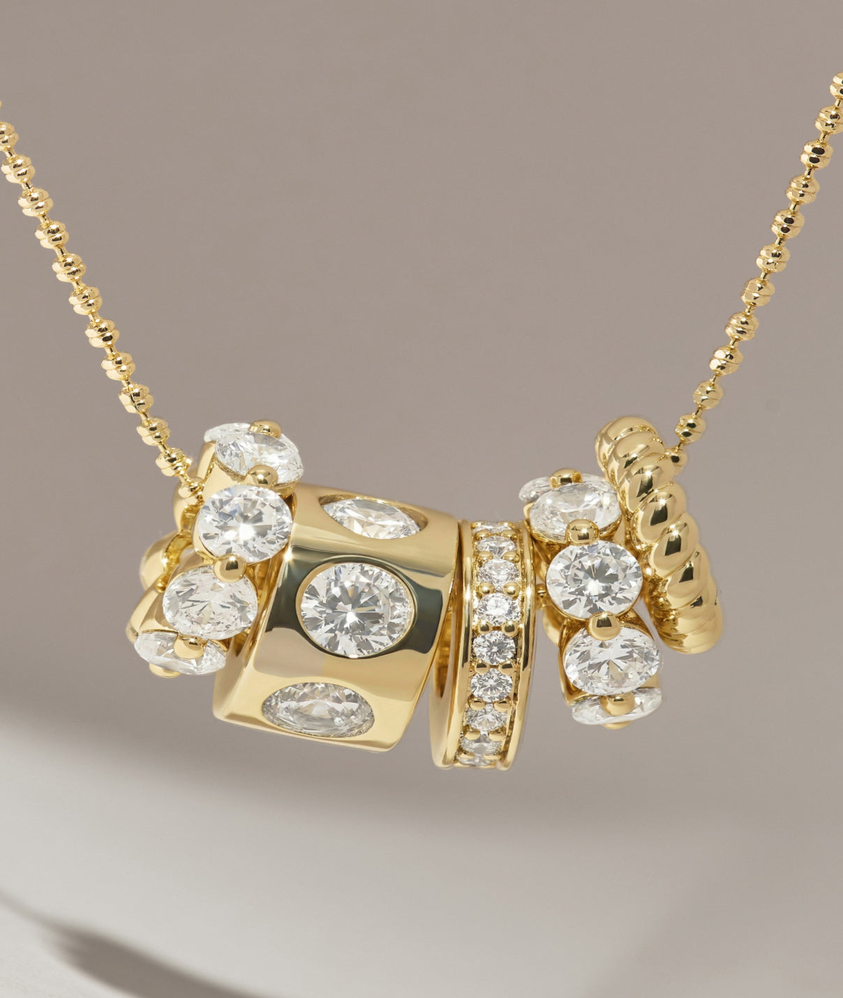 Gold necklace with diamond pendants on a neutral background