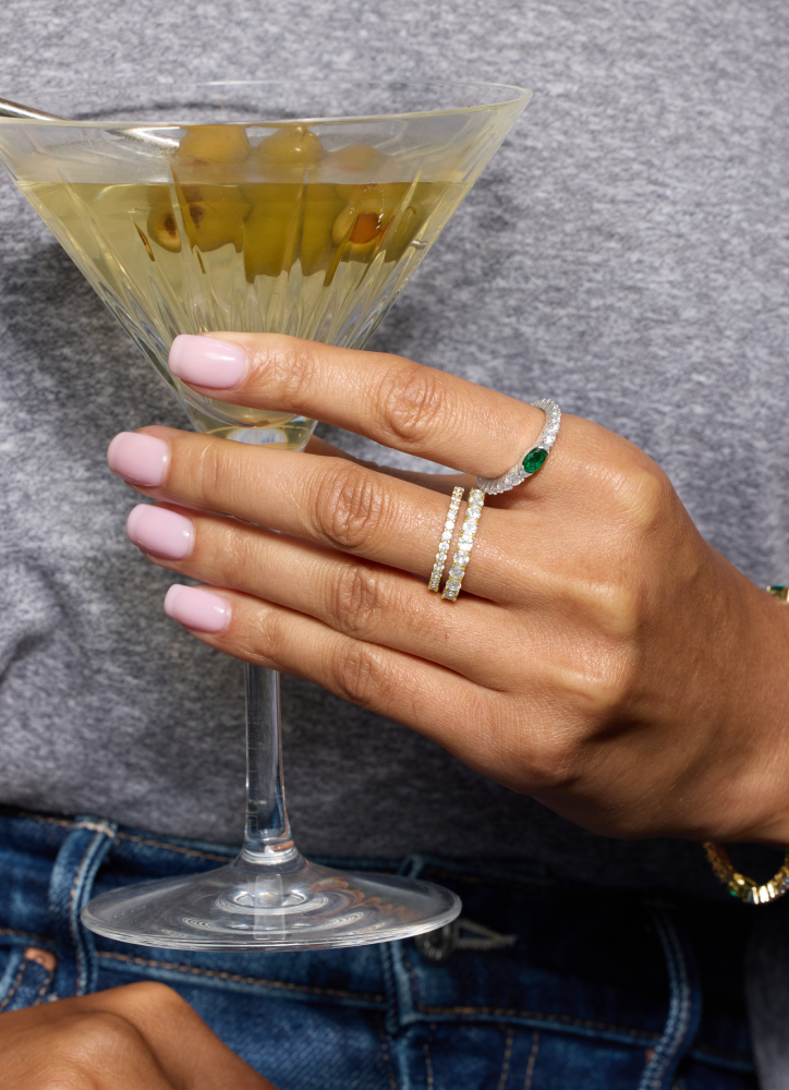 Hand holding a cocktail glass with a gray background