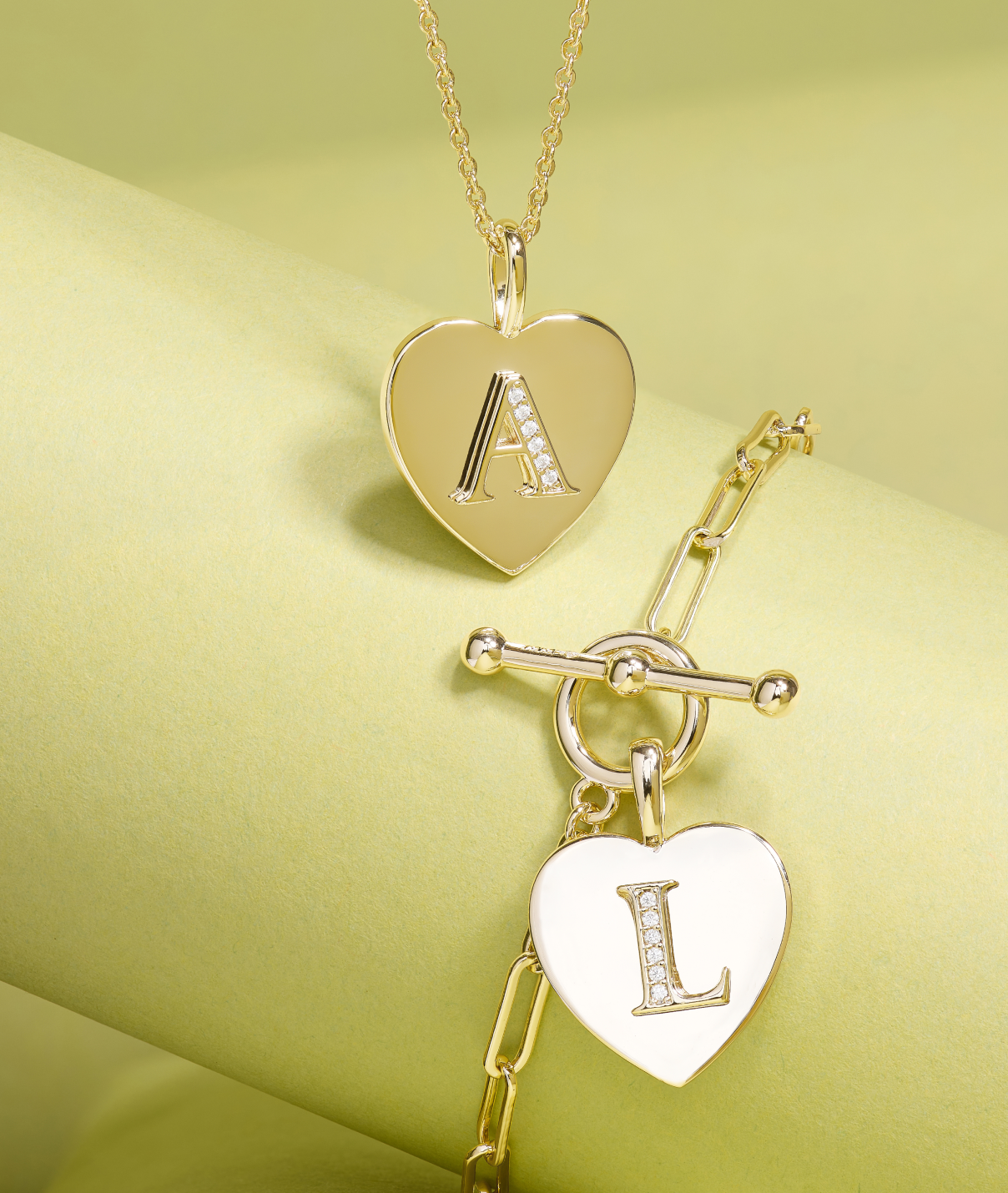 Gold heart-shaped pendant with 'A' and 'L' on a yellow background