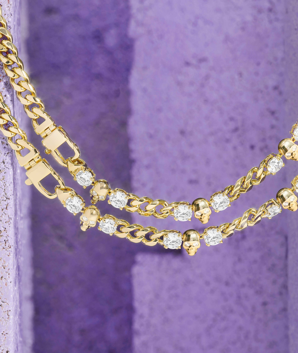 Gold chain with diamond-like stones on a textured purple background