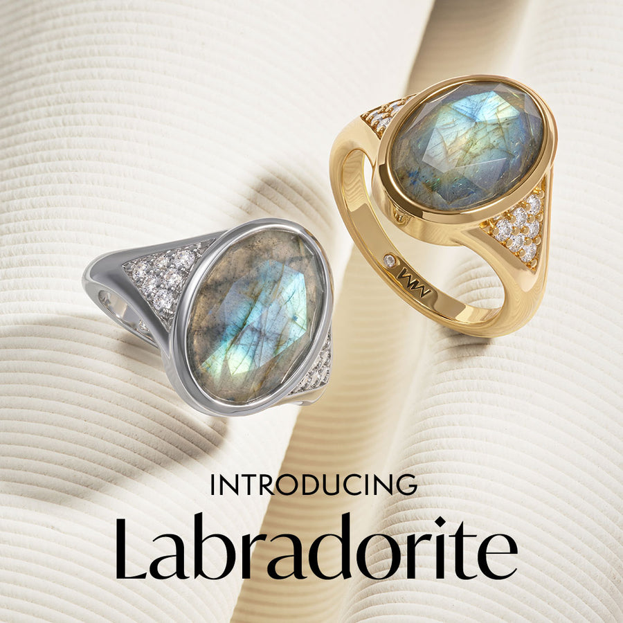 Two Labradorite rings, one in gold and one in silver, on a textured beige background with 'Labradorite' text.