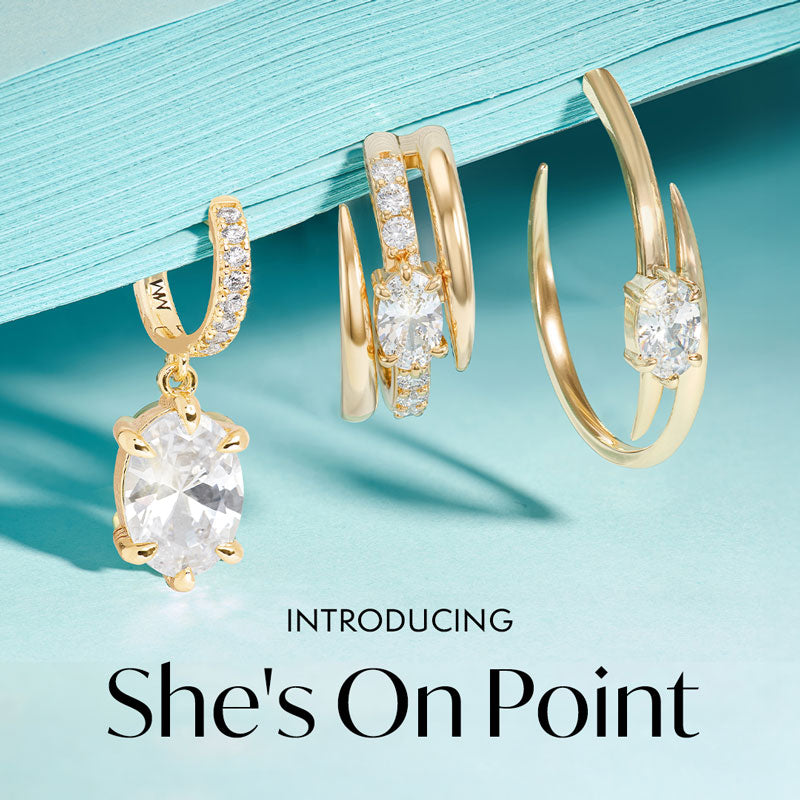 Gold hoop earrings with clear gemstones on a light blue background, introducing 'She's On Point' brand.