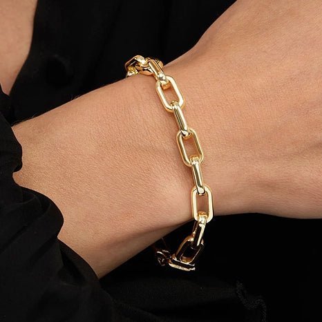 Model wearing a gold chain link bracelet