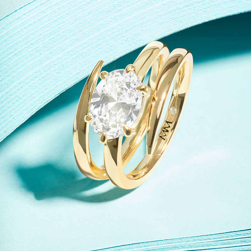 Gold ring with a diamond on a light blue background