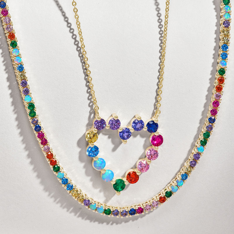 Colorful heart-shaped necklace with multicolored stones on a light gray background