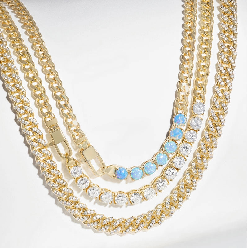 Three gold-toned chain necklaces layered together on a white background. 