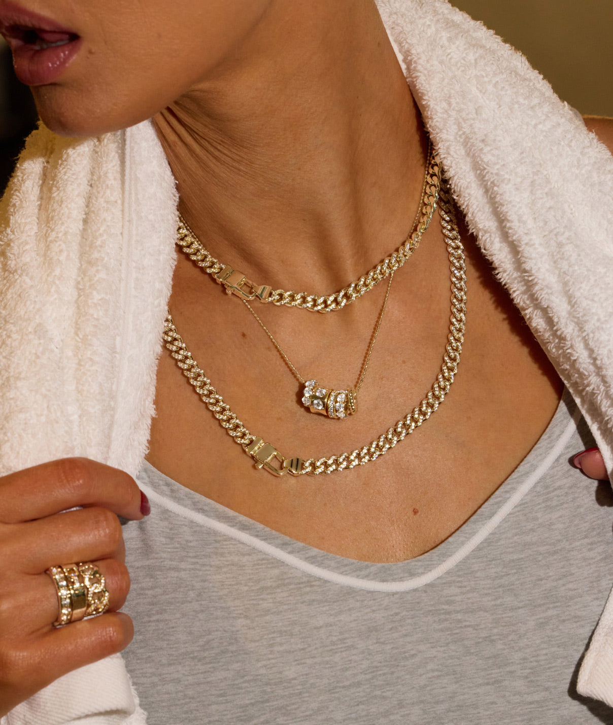 Close-up of a person wearing gold necklaces and a ring.