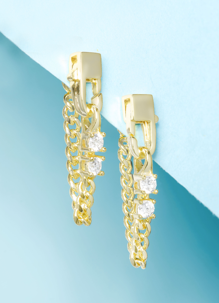 Gold chain earrings with clear stones on a blue and green gradient background