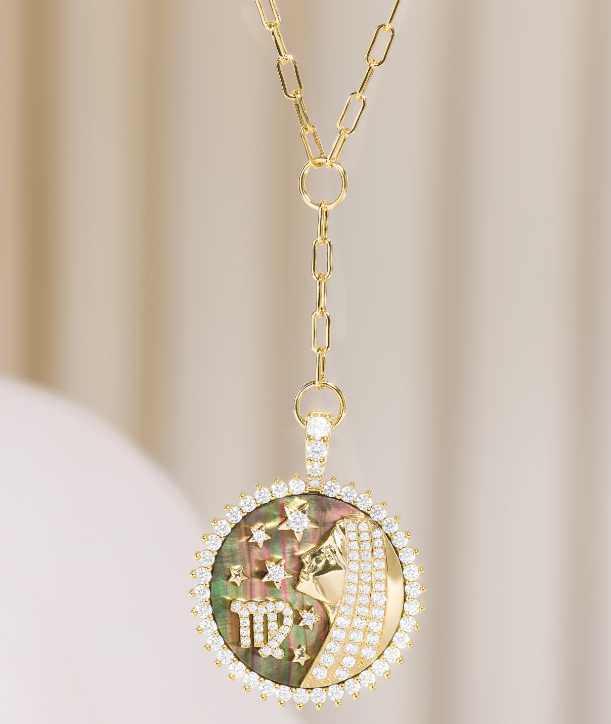 Gold necklace with a Virgo zodiac pendant on a beige background