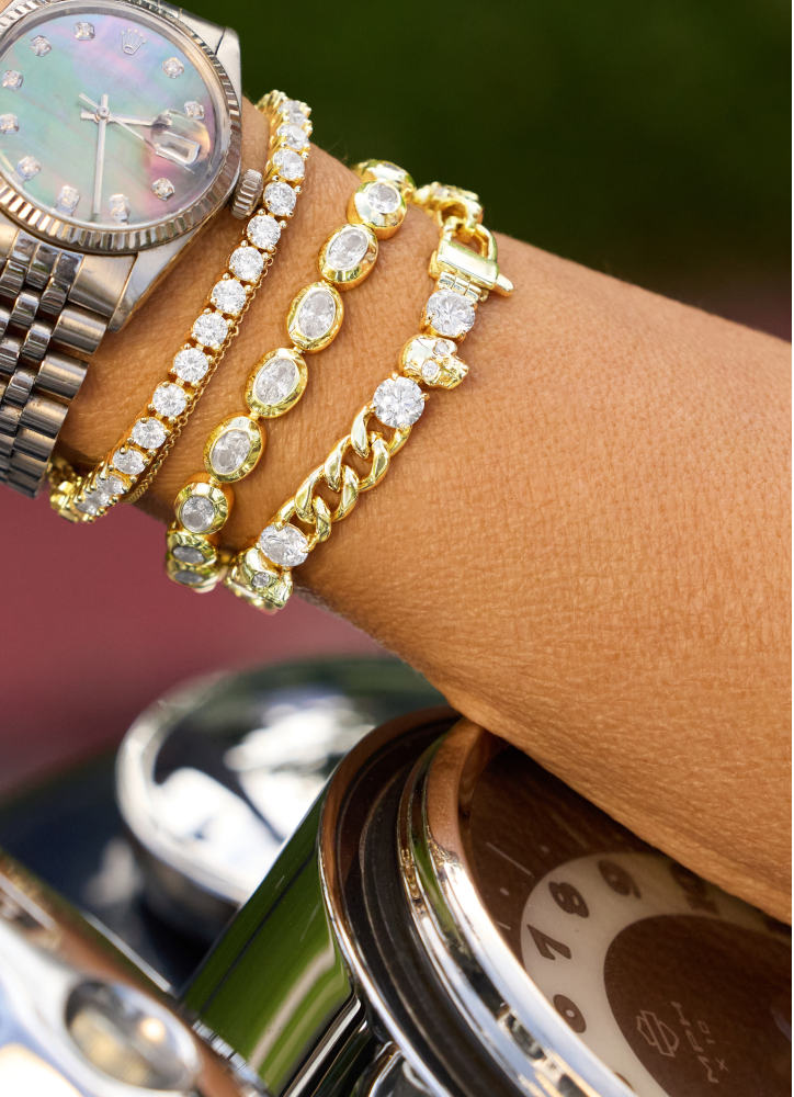 Gold bracelets on a wrist with a blurred background