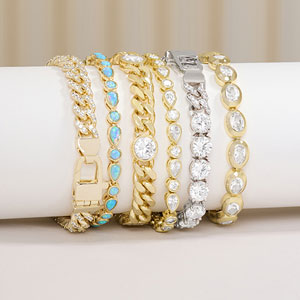 Set of gold and silver bracelets with gemstones on a white surface