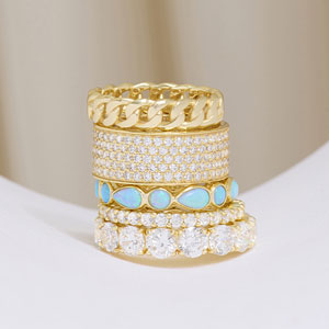 Set of gold rings with various designs on a white surface