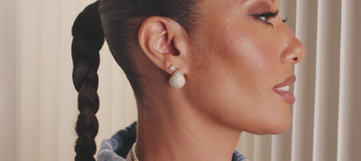 Model wearing pieces from the New Norah Collection against a cream colored background